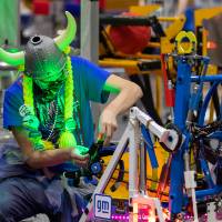 A team member works on a robot on the field